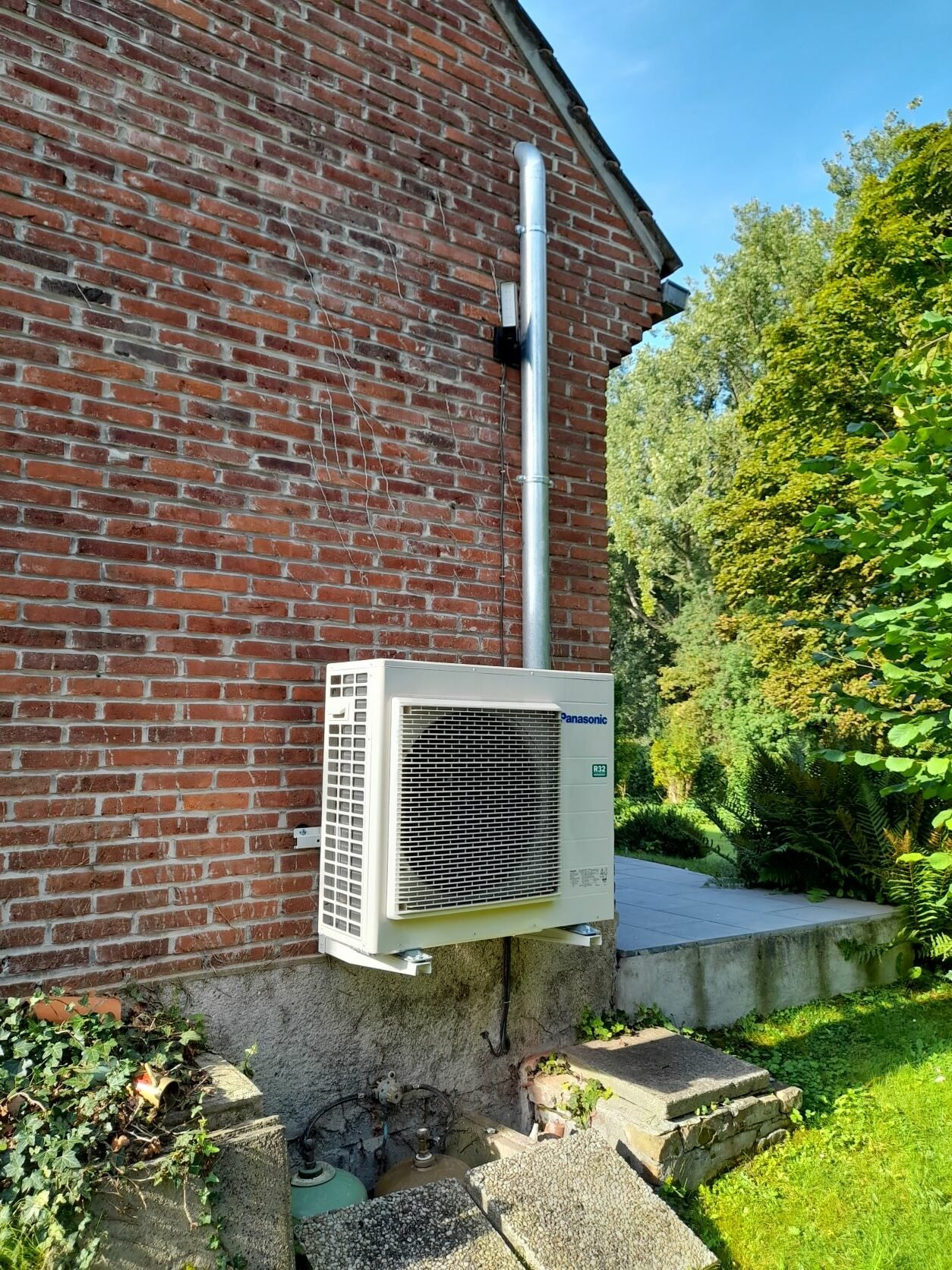 Unité extérieure de pompe à chaleur air/eau installée sur la façade d’une maison contemporaine
